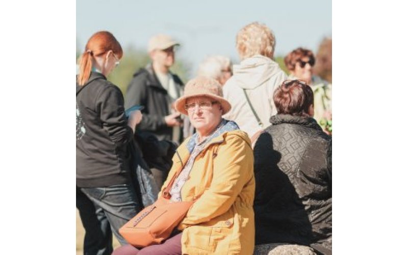 Person in hat facing camera with the backs of other people behind them