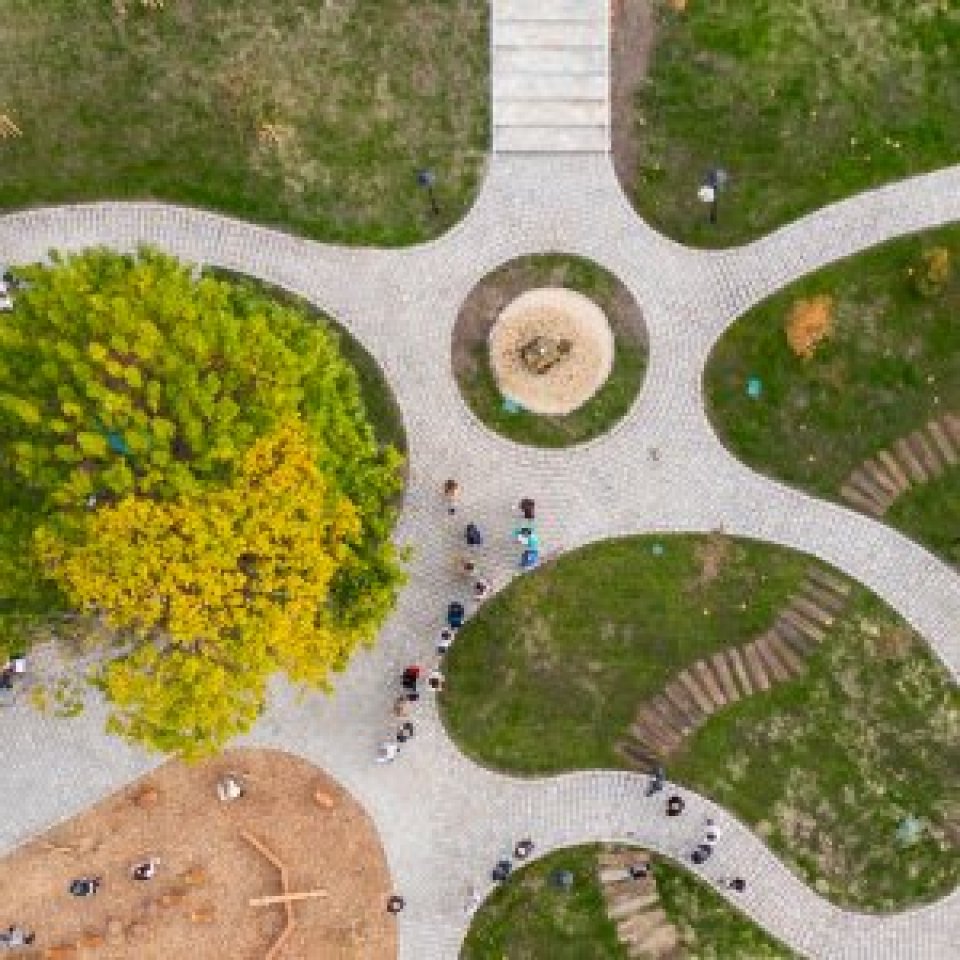 Aerial view of path radiating from a centre point with grassland between the paths