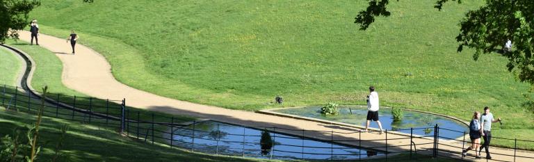 people running by a stream long footpath meandering through greenspace