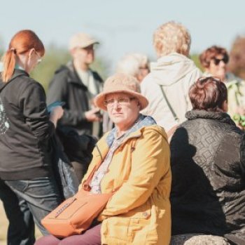 Person in hat facing camera with the backs of other people behind them
