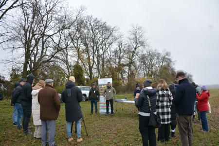 on the ground team in green field with trees with no leaves on
