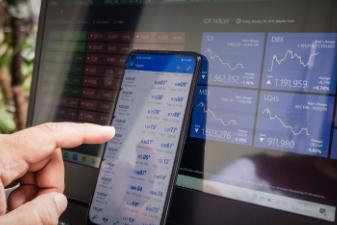 someone tapping on a phone with logistics on background screen