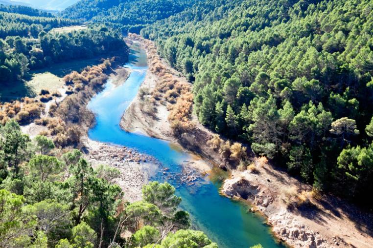 Guadalquivir River with steep and wooded valley sides.