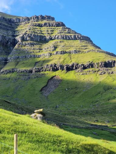 Tall hillside with bands of exposed rock and patches of erosion.