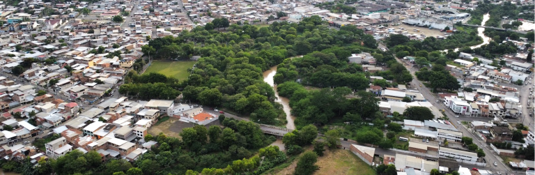 An elevated view of Portoviejo showing a greenspace surrounded by very dense urban development.